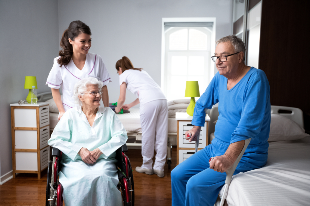 Staff helping elder patients in their room
