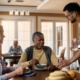 Young caregiver serving a glass of water to senior people during lunch in nursing home.
